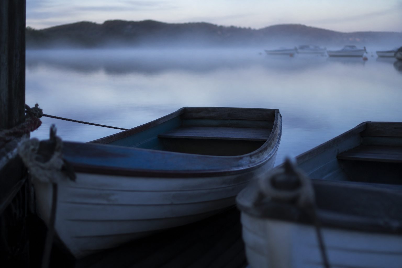 Small boats moored in a calm harbour at first light.
